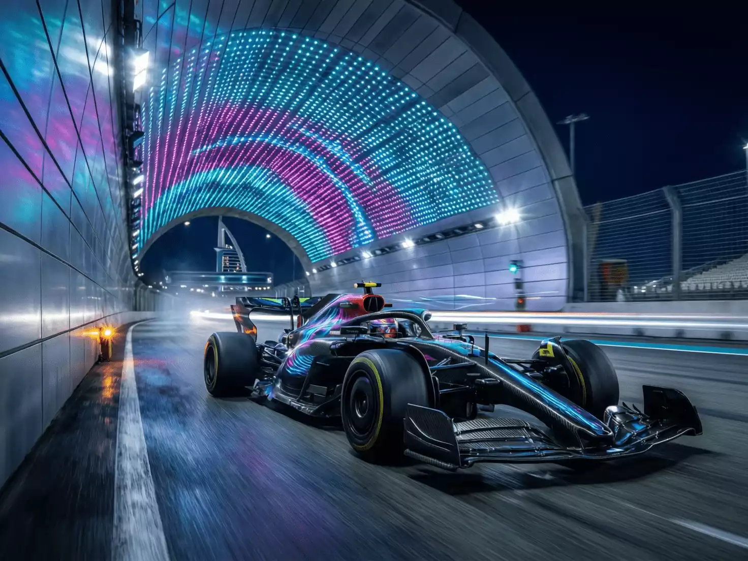 Monoplaza de F1 atravesando la sección bajo el hotel W Abu Dhabi de noche